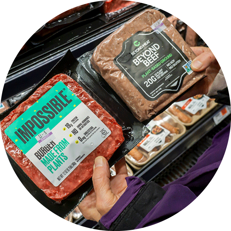 Alternative protein company database 1 A shopper compares plant-based meat products in a supermarket aisle